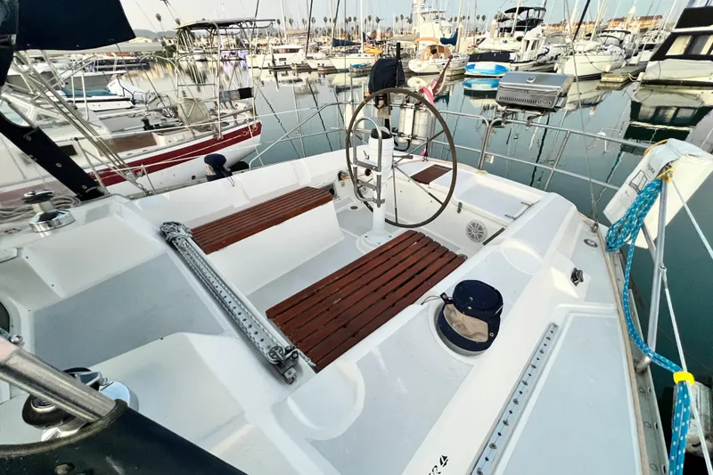 Slide: The Image of 1990 Hunter Legend 40 sailboat cockpit with wooden seating, docked in a marina. - 10