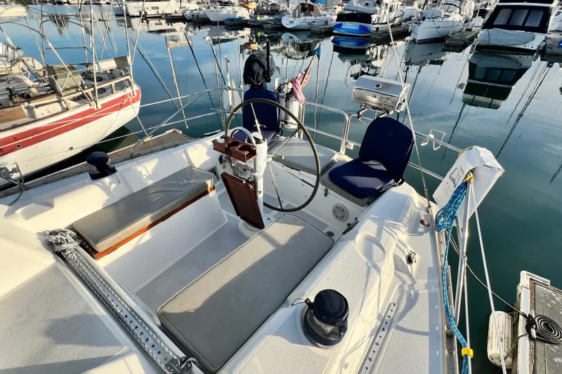 Slide: The Image of 1990 Hunter Legend 40 sailboat cockpit with steering wheel, marina background. - 11