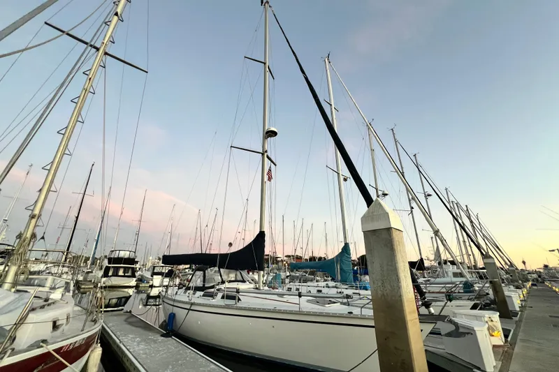 Slide: The Image of Sailboats docked at marina during sunset, featuring a 1990 Hunter Legend 40. - 2