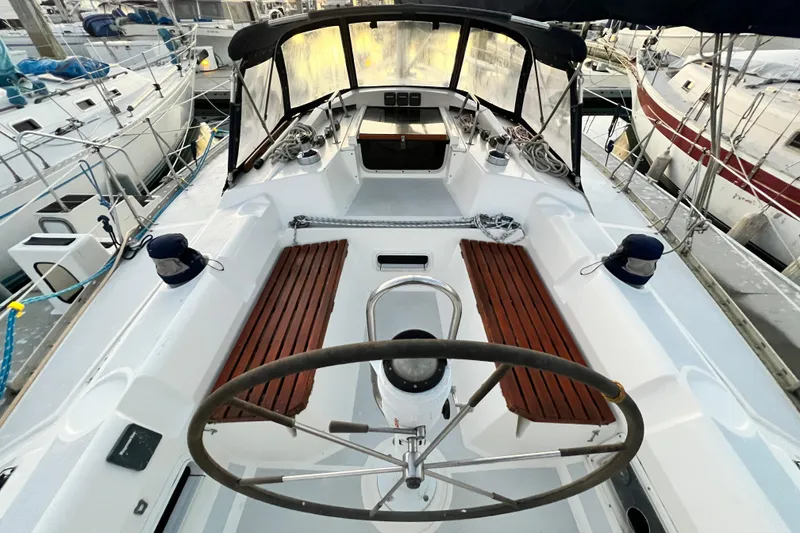 Slide: The Image of Cockpit of 1990 Hunter Legend 40 sailboat with wooden benches and steering wheel. - 21