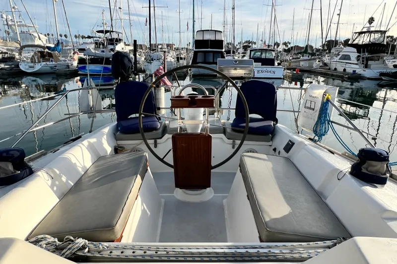Slide: The Image of 1990 Hunter Legend 40 sailboat cockpit with marina view, featuring steering wheel and seating. - 22