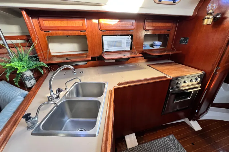 Slide: The Image of 1990 Hunter Legend 40 yacht kitchen with double sink, stove, and microwave. - 27