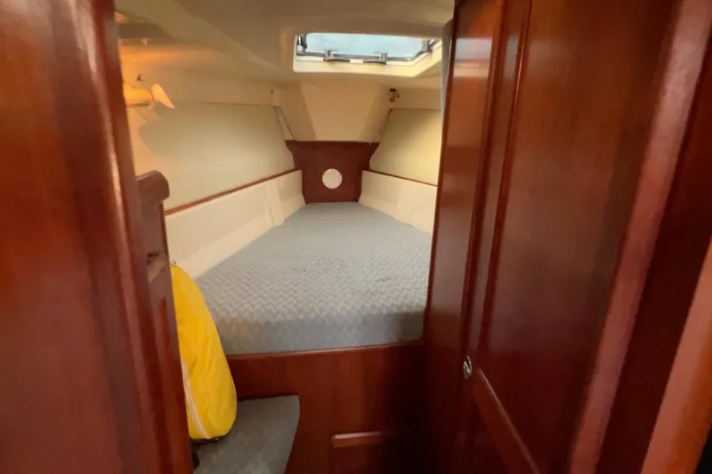 Slide: The Image of Interior cabin of 1990 Hunter Legend 40 sailboat with wooden finish and cozy sleeping area. - 38