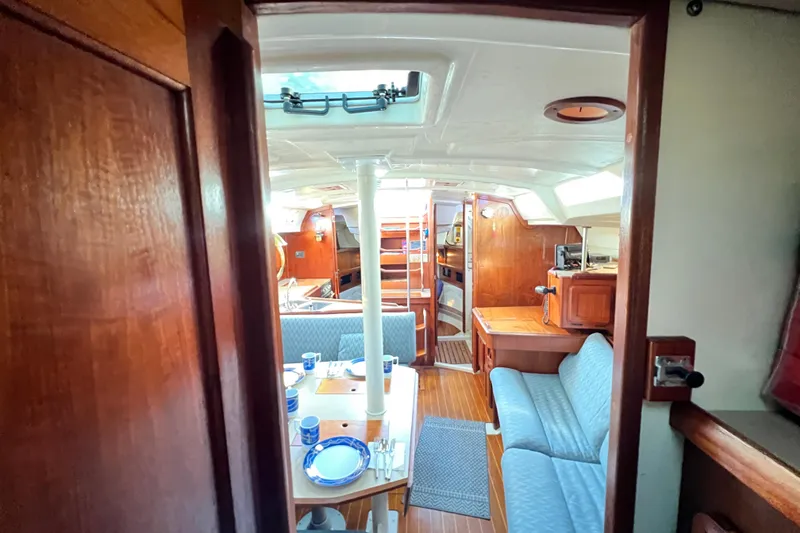 Slide: The Image of Interior of 1990 Hunter Legend 40 sailboat with dining area and wooden furnishings. - 41