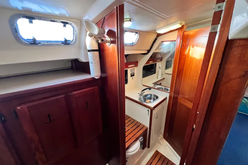 Slide: The Image of Interior of 1990 Hunter Legend 40 sailboat with wooden cabinetry and compact kitchen area. - 45