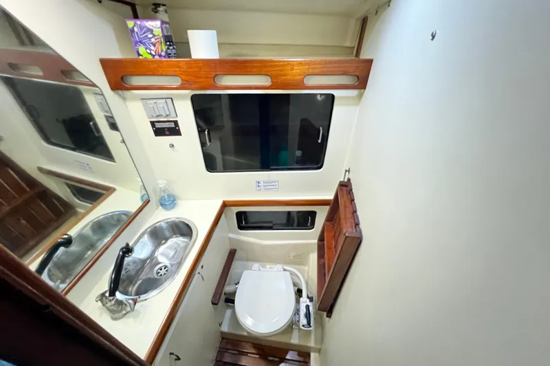Slide: The Image of Compact bathroom in a 1990 Hunter Legend 40 yacht, featuring a sink and toilet. - 46