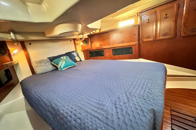 Slide: The Image of Cozy cabin interior of 1990 Hunter Legend 40 sailboat with blue bedding and wooden cabinets. - 49