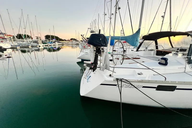 Slide: The Image of Hunter Legend 40 sailboat docked in a serene marina at sunset, 1990 model. - 5