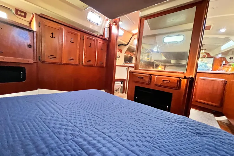 Slide: The Image of Interior of 1990 Hunter Legend 40 sailboat with wooden cabinetry and blue bedding. - 50