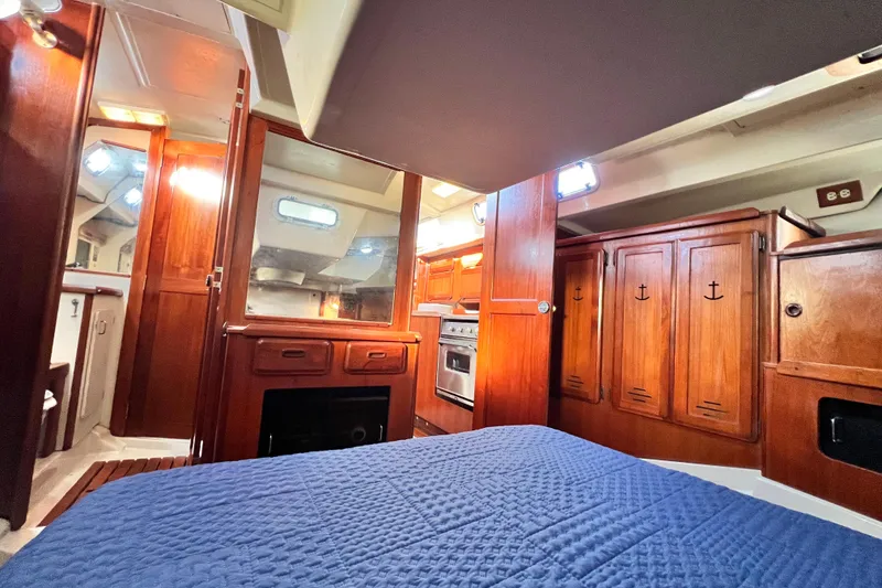 Slide: The Image of Interior of 1990 Hunter Legend 40 sailboat with wooden cabinetry and blue bedding. - 51
