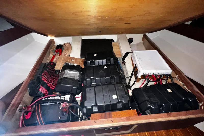 Slide: The Image of Battery compartment of a 1990 Hunter Legend 40 sailboat, showing multiple batteries and wiring. - 55