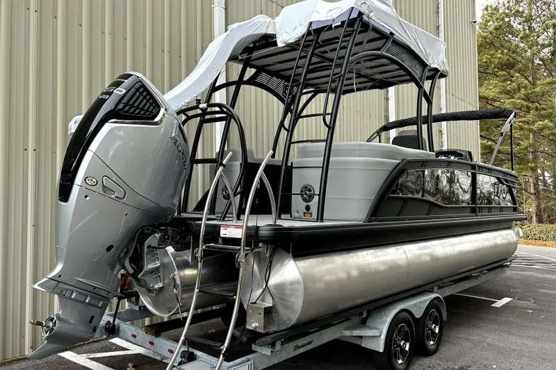 Slide: The Image of 2026 Godfrey Monaco 255 SDC pontoon boat on trailer, featuring powerful outboard motor. - 1