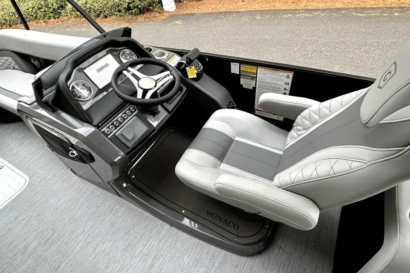 Slide: The Image of 2026 Godfrey Monaco 255 SDC boat interior with steering wheel and captain's chair. - 4