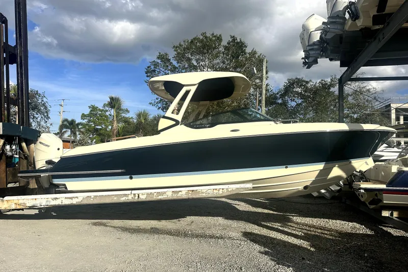 The Image of 2026 Chris-Craft Sportster 28 boat on a lift under cloudy sky. - 0