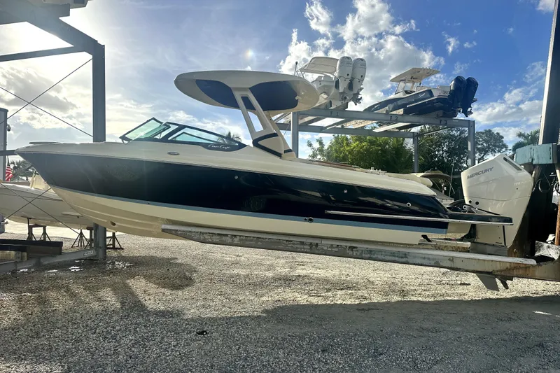 Slide: The Image of 2026 Chris-Craft Sportster 28 boat on a lift under a clear blue sky. - 3