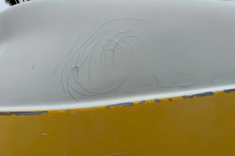 Slide: The Image of Close-up of 2003 VIP Deckliner 224 boat with visible scratches and paint wear. - 10