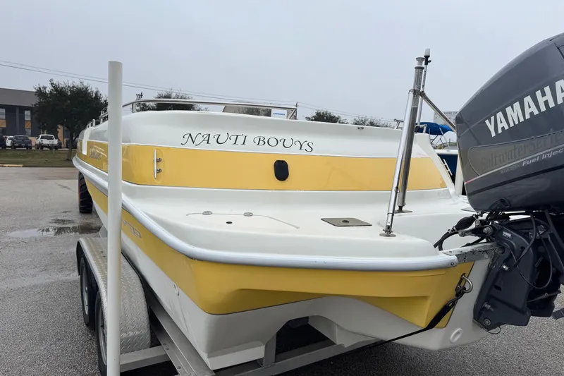 Slide: The Image of 2003 VIP Deckliner 224 boat with Yamaha engine on trailer, labeled "NAUTI BOUYS." - 12