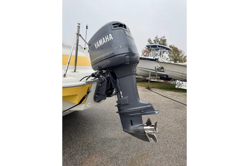 Slide: The Image of 2003 VIP Deckliner 224 boat with Yamaha outboard motor in a marina setting. - 13