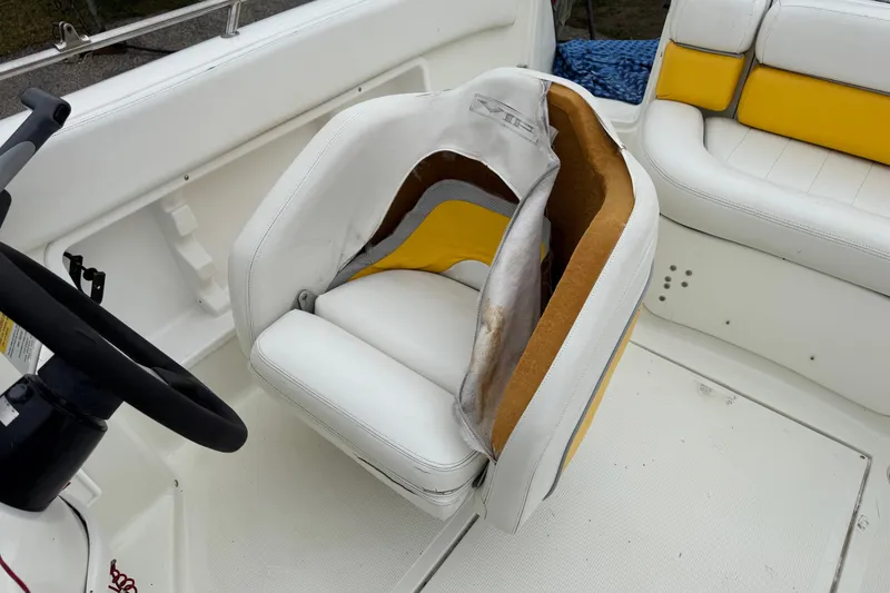 Slide: The Image of 2003 VIP Deckliner 224 boat interior with damaged white and yellow seat upholstery. - 18