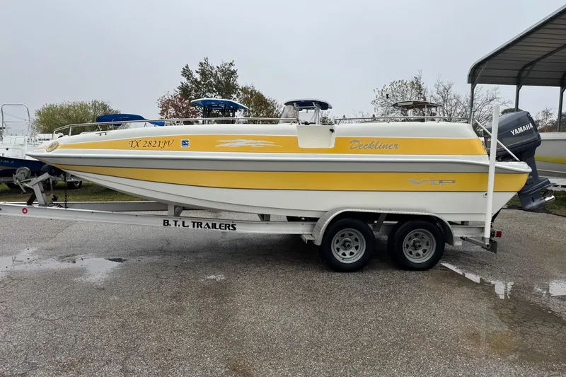 Slide: The Image of 2003 VIP Deckliner 224 boat on trailer, yellow and white design, parked outdoors. - 2