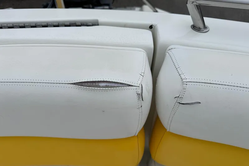 Slide: The Image of Torn white upholstery on 2003 VIP Deckliner 224 boat seat, showing wear and damage. - 22