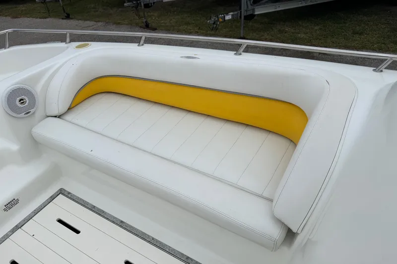 Slide: The Image of White and yellow seating on 2003 VIP Deckliner 224 boat, featuring integrated speaker. - 26