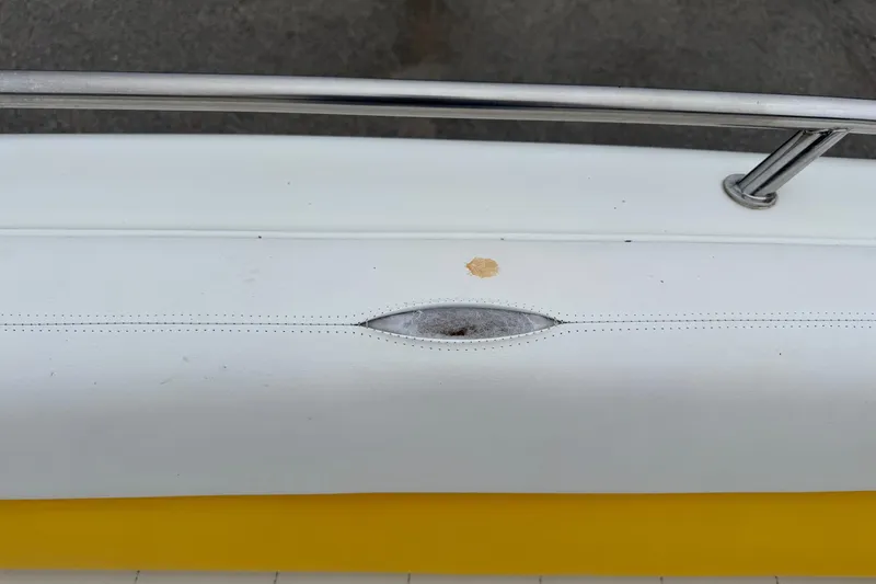 Slide: The Image of 2003 VIP Deckliner 224 boat detail with white upholstery and metal railing. - 31