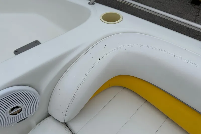 Slide: The Image of 2003 VIP Deckliner 224 boat interior with white and yellow seating, speaker, and cup holder. - 32