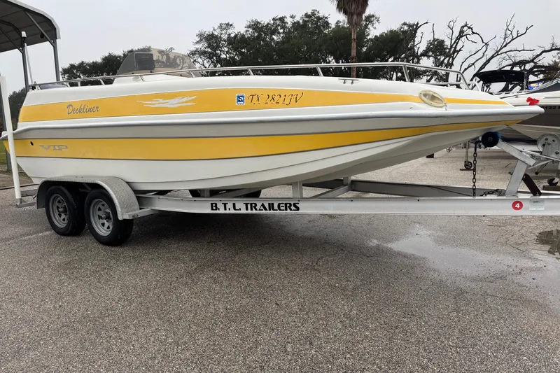 Slide: The Image of 2003 VIP Deckliner 224 boat on trailer, yellow and white design, parked outdoors. - 4