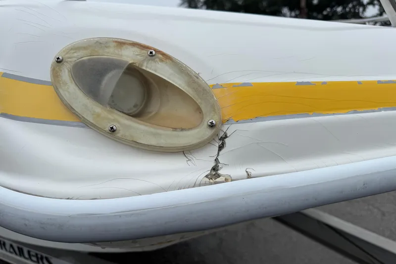 Slide: The Image of Damaged 2003 VIP Deckliner 224 boat hull with cracked yellow stripe and worn light fixture. - 5