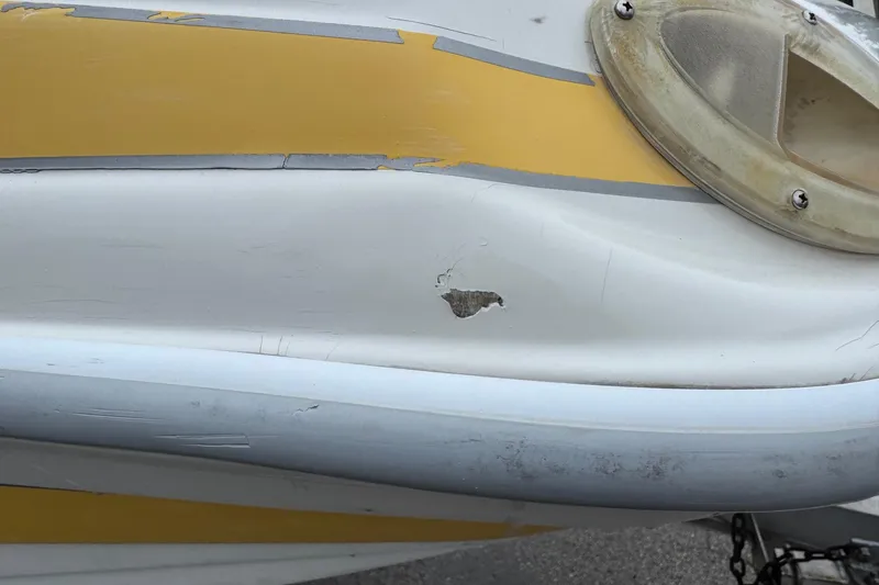 Slide: The Image of 2003 VIP Deckliner 224 boat with visible hull damage and peeling paint. - 6