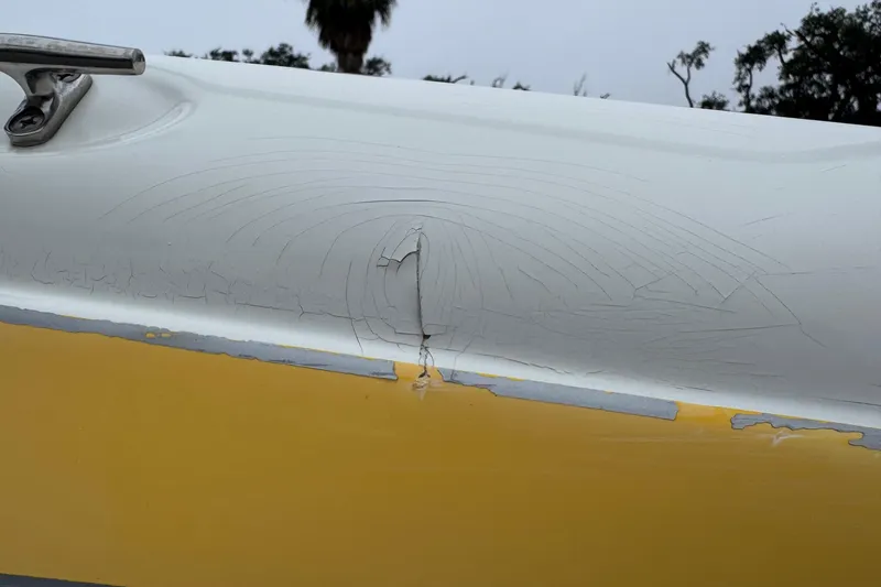 Slide: The Image of Cracked paint on 2003 VIP Deckliner 224 boat hull, showing wear and damage. - 7