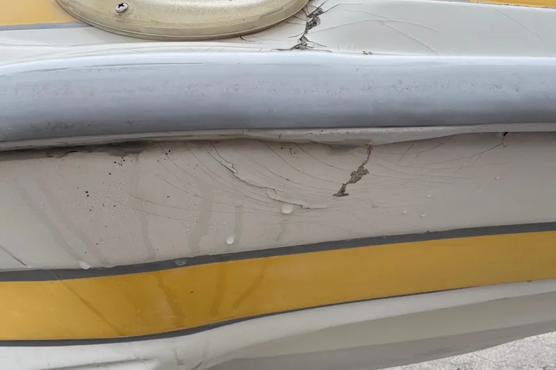 Slide: The Image of 2003 VIP Deckliner 224 boat with visible hull damage and cracks. - 8
