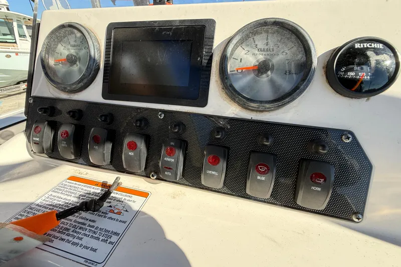 Slide: The Image of Dashboard of 2019 Yamaha Boats 210 FSH Sport with gauges and control switches. - 16