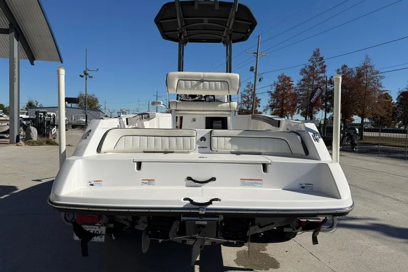 Slide: The Image of 2019 Yamaha Boats 210 FSH Sport, rear view, parked outdoors on a sunny day. - 6