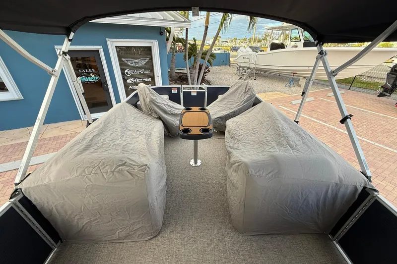 Slide: The Image of 2019 Bennington R 25 RL pontoon boat interior with covered seating and table. - 25