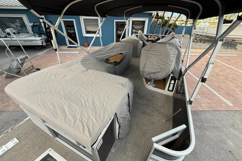 Slide: The Image of 2019 Bennington R 25 RL pontoon boat with protective covers in a marina setting. - 27