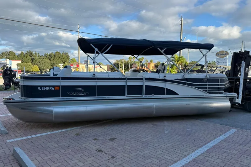 Slide: The Image of 2019 Bennington R 25 RL pontoon boat with canopy on paved lot. - 5