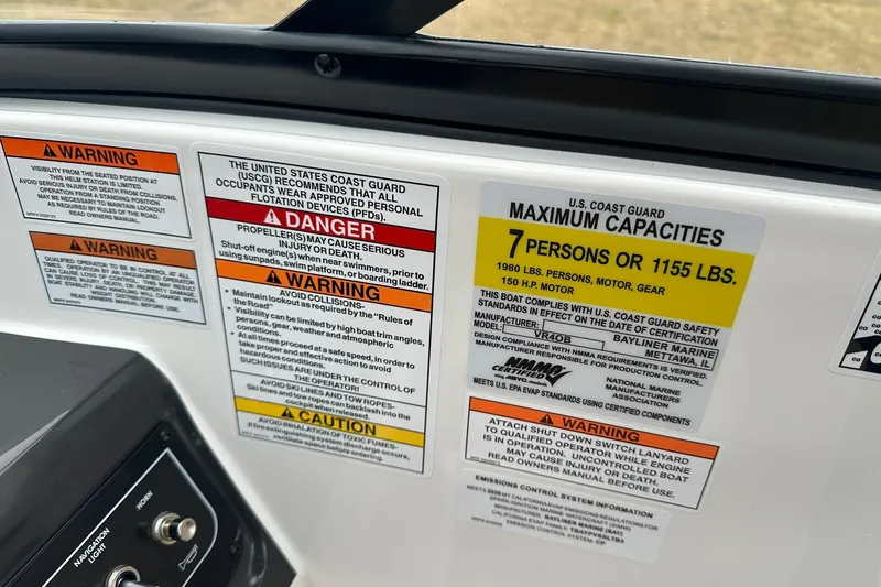 Slide: The Image of Bayliner VR4 Bowrider OB 2026 capacity warning labels, maximum 7 persons or 1155 lbs. - 12