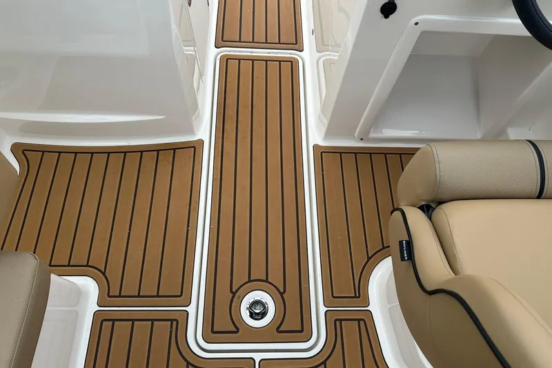 Slide: The Image of 2026 Bayliner VR4 Bowrider OB interior with teak-style flooring and beige seating. - 16