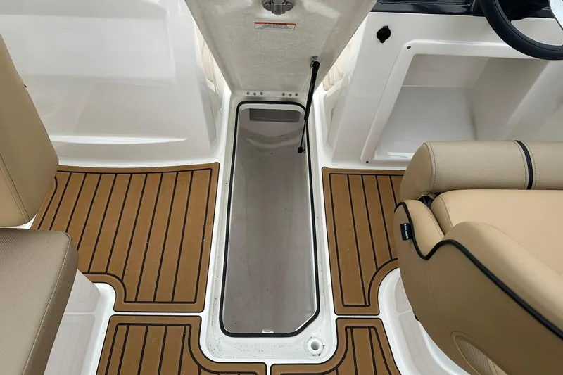 Slide: The Image of 2026 Bayliner VR4 Bowrider OB interior with open storage compartment and tan seating. - 17