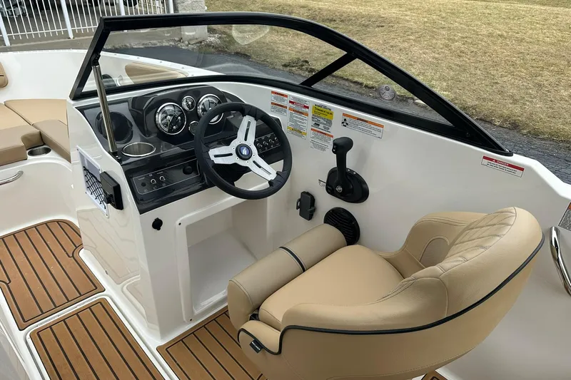 Slide: The Image of 2026 Bayliner VR4 Bowrider OB interior with steering wheel and beige seating. - 8