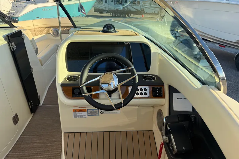 Slide: The Image of 2026 Chris-Craft Calypso 28 boat helm with steering wheel and control panel. - 14