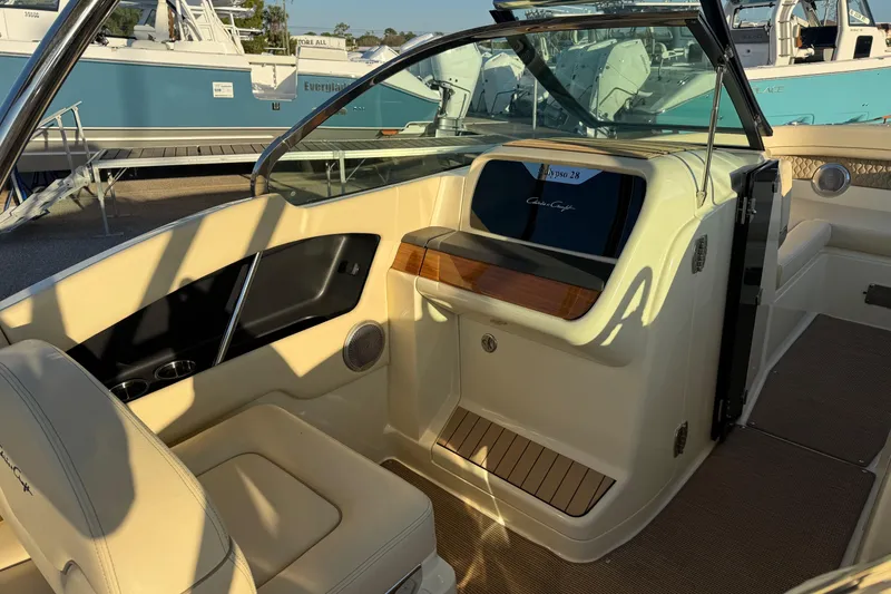 Slide: The Image of 2026 Chris-Craft Calypso 28 boat interior with beige seating and sleek dashboard design. - 15