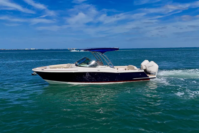 Slide: The Image of 2026 Chris-Craft Calypso 28 boat cruising on open water under a clear blue sky. - 20