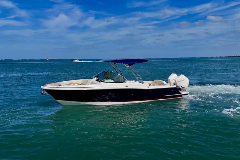 Slide: The Image of 2026 Chris-Craft Calypso 28 boat cruising on open water under a clear blue sky. - 22