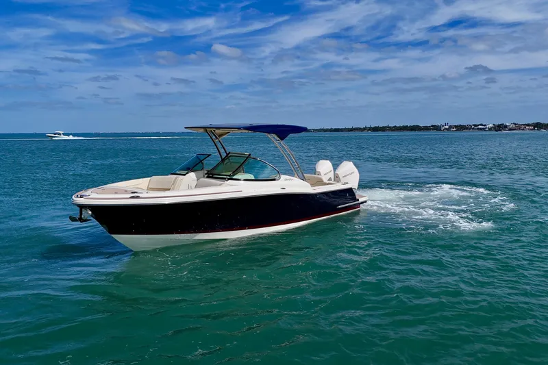 Slide: The Image of 2026 Chris-Craft Calypso 28 boat cruising on clear blue water under a sunny sky. - 23