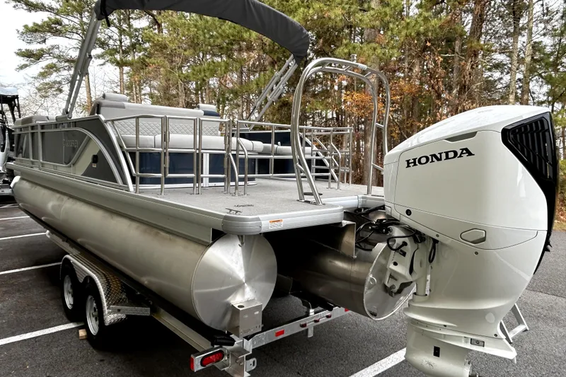 Slide: The Image of 2026 Godfrey Sweetwater 2286 SFLC pontoon boat with Honda outboard motor in a wooded area. - 3