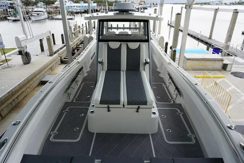 Slide: The Image of 2023 Insetta 35IFC boat interior with sleek seating and modern design at a marina. - 21