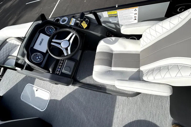 Slide: The Image of 2026 Godfrey Monaco 235 ULC boat interior with steering wheel and plush seating. - 10